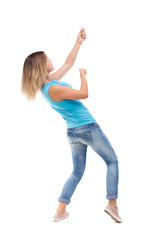 back view of standing girl pulling a rope from the top or cling