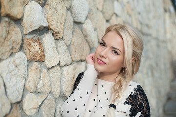 Portrait  pretty young girl near stone wall