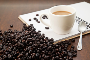 Cup of coffee and book with beans