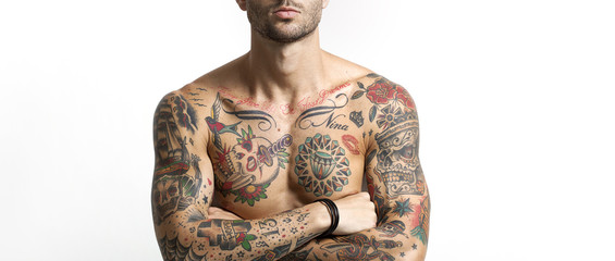 Handsome and sexy tattooed man portrait with crossed arms letter