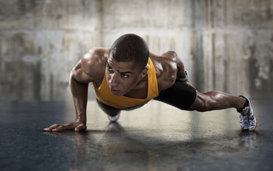 Sport. Young athletic man doing push-ups. Muscular and strong guy exercising.