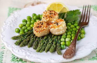 A delicious dinner of roasted scallops, asparagus and green peas
