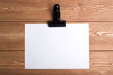 Writing paper with a clip on the wood background 