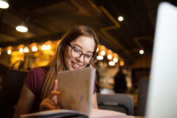Beautiful woman in a cafe talking on the phone and smile