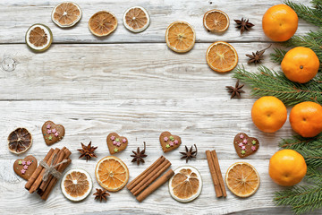 Mandarins with  cristmas tree branch  with cinnamon, anise, cookies  on white wooden background 