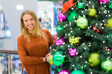 Portrait einer jungen Frau neben einem Weihnachtsbaum