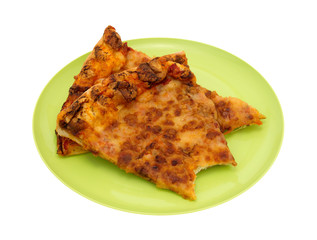 Leftover cheese pizza bitten on green plate