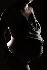 Naklejka premium Babybauch sinnlich mit Schattenlichter Nahaufnahme