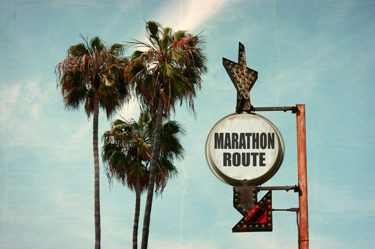 aged and worn vintage photo of marathon route sign with palm trees
