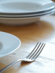 Fork and plates lying on wooden table