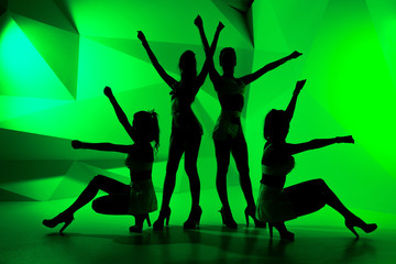 Silhouettes of four slim posturing girls