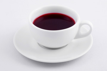 white tea cup with red tea on white background