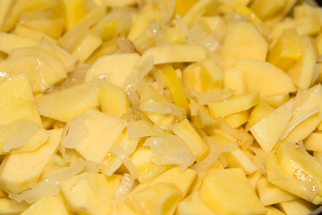 potatoes and onions in a frying pan as background