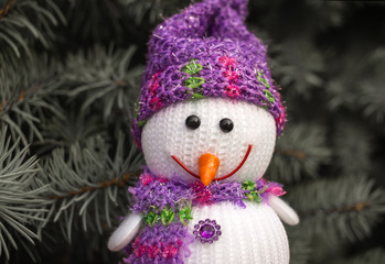  merry snowman looks smiling on the background of Christmas tree