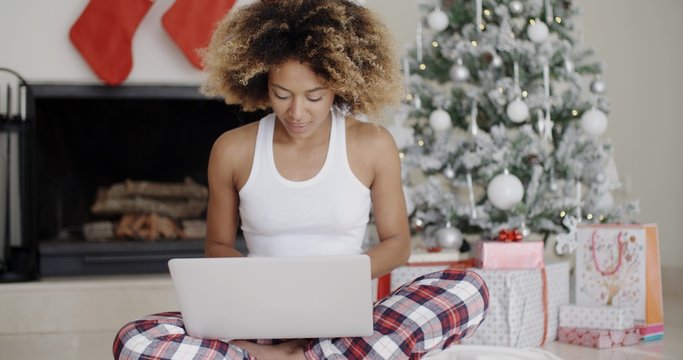 Woman using a laptop in front of the Xmas tree
