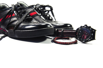 Black men shoes with red stripe, watch and bracelet isolated by white background