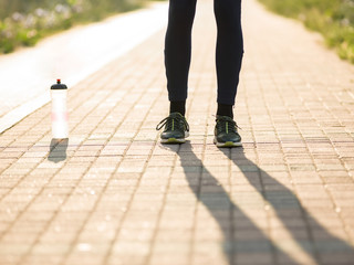 Portrait of a male runner tying sport shoe shoelace outside