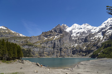 View of Oeschinensee lake with Bluemlisalp and Frundenhorn peaks in Kandersteg, Switzerland