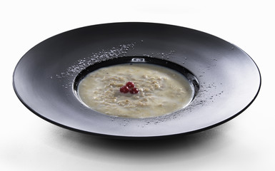 Plate of porridge on white table