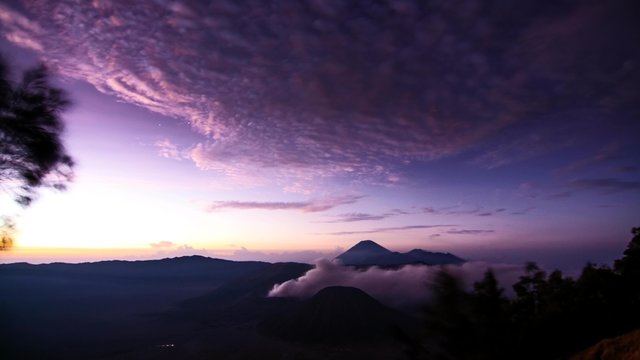 Bromo Tengger Semeru National Park, East Java, Indonesia time lapse consist of milky way of stars and a sunrise with Mount Batok, Bromo and Semeru in the center.