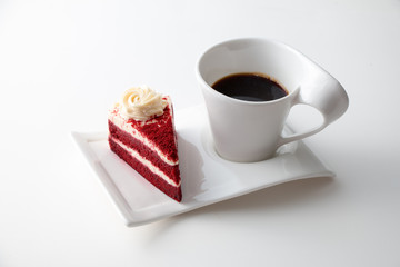 Cup of coffee with delicious red velvet cake isolated on white background