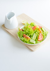  salad in a bowl on wooden witth jug