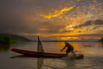 silhouette fisherman of Bangpra Lake in action when fishing, Tha
