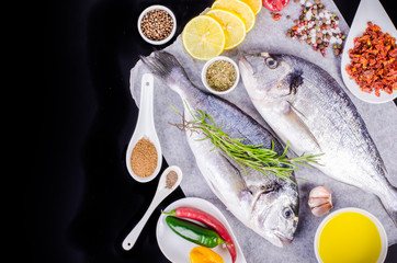 Cooking ingredients. Lemon, olive oil, herbs, salt, pepper on paper. Black background. Healthy food concept. Food frame