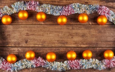 Christmas Baubles And Tinsel Garland On Old Wooden Boards