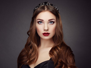Fototapeta premium Fashion portrait of elegant woman with magnificent hair. Brunette girl. Perfect make-up. Girl in black dress. Curly hair