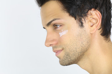 Fototapeta premium Close portrait of a man with moisturizer on her face