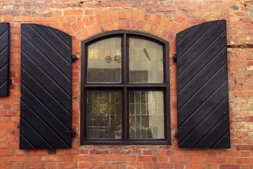  wall of red brick with window and shutters