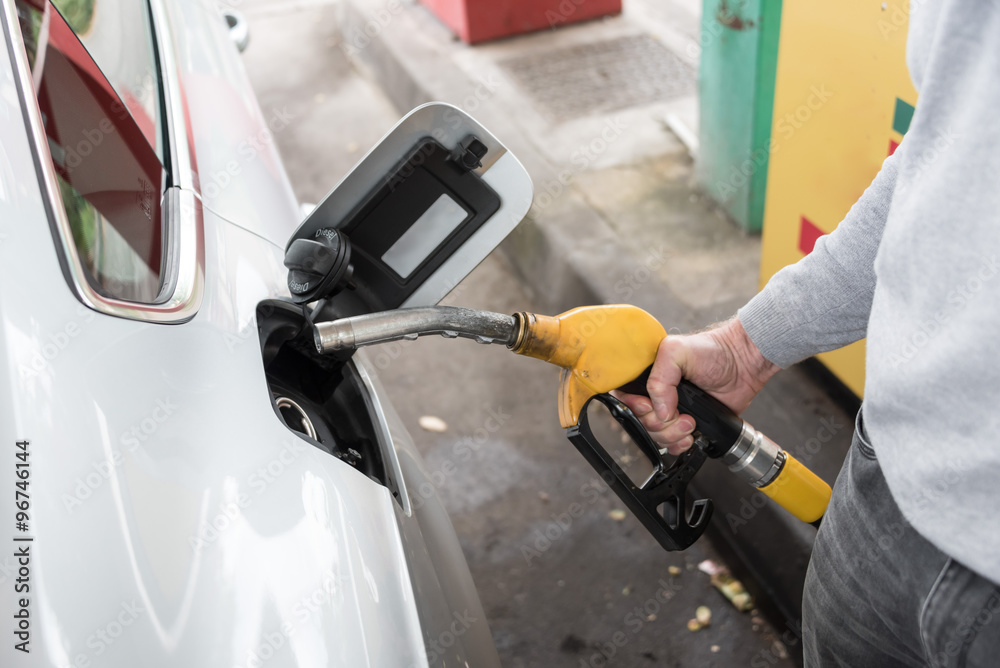 Wall mural Man holding a fuel pump nozzle