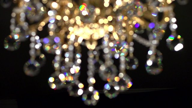 Crystal chandelier on black background. Crystals sway and sparkle. 