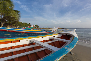 Colorful wooden fisher boats anchored in the bay of Pampatar with loads on the wooden pier. Margarita Island. Venezuela 2015