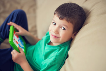 Little caucasian boy counting on abacus