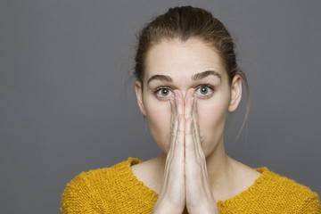 negative feelings concept - speechless beautiful 20s girl covering her mouth and nose for regret or...