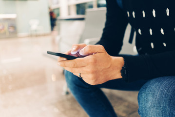 Young man using smartphone while waiting for boarding a plane