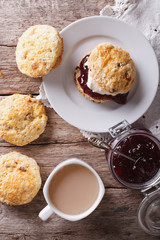 Delicious English scones with jam and tea closeup. vertical top view
