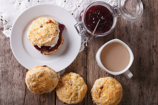 Delicious English scones with jam and tea close-up. Horizontal top view
