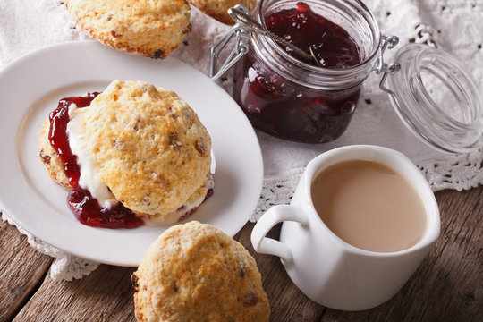 Homemade scones with jam and tea with milk close-up. horizontal
