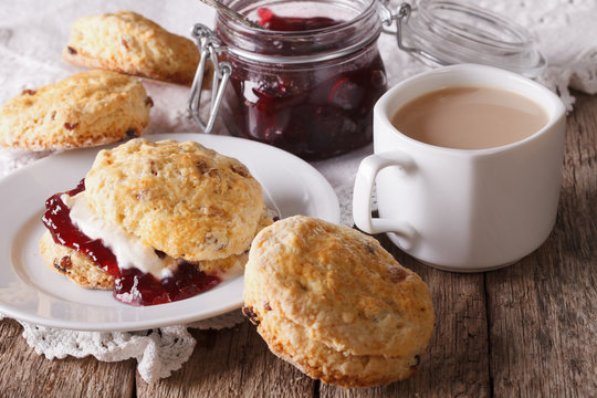 Naklejki Scones with jam and tea with milk on the table. horizontal  