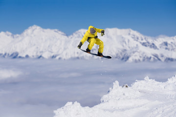 Flying snowboarder on mountains. Extreme sport.