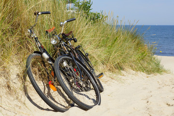 Fototapeta premium Two Bikes at the Summer Beach with Sea in the background