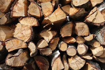Fototapeta premium Background of dry chopped firewood logs stacked up in a pile