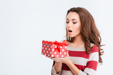 Young amazed woman holding gift box