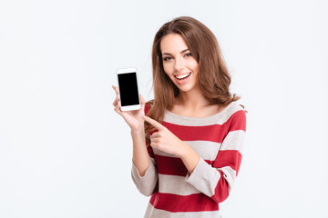 Cheerful woman showing blank smartphone screen