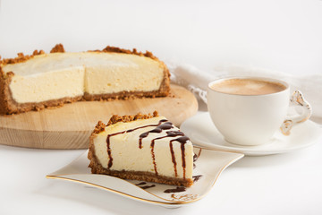 Cheesecake with chocolate and coffee on a white table