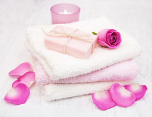 Obraz na płótnie Canvas Bath towels and soap with pink roses