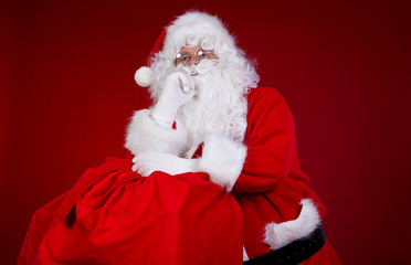 Santa Claus carrying big bag , on red background